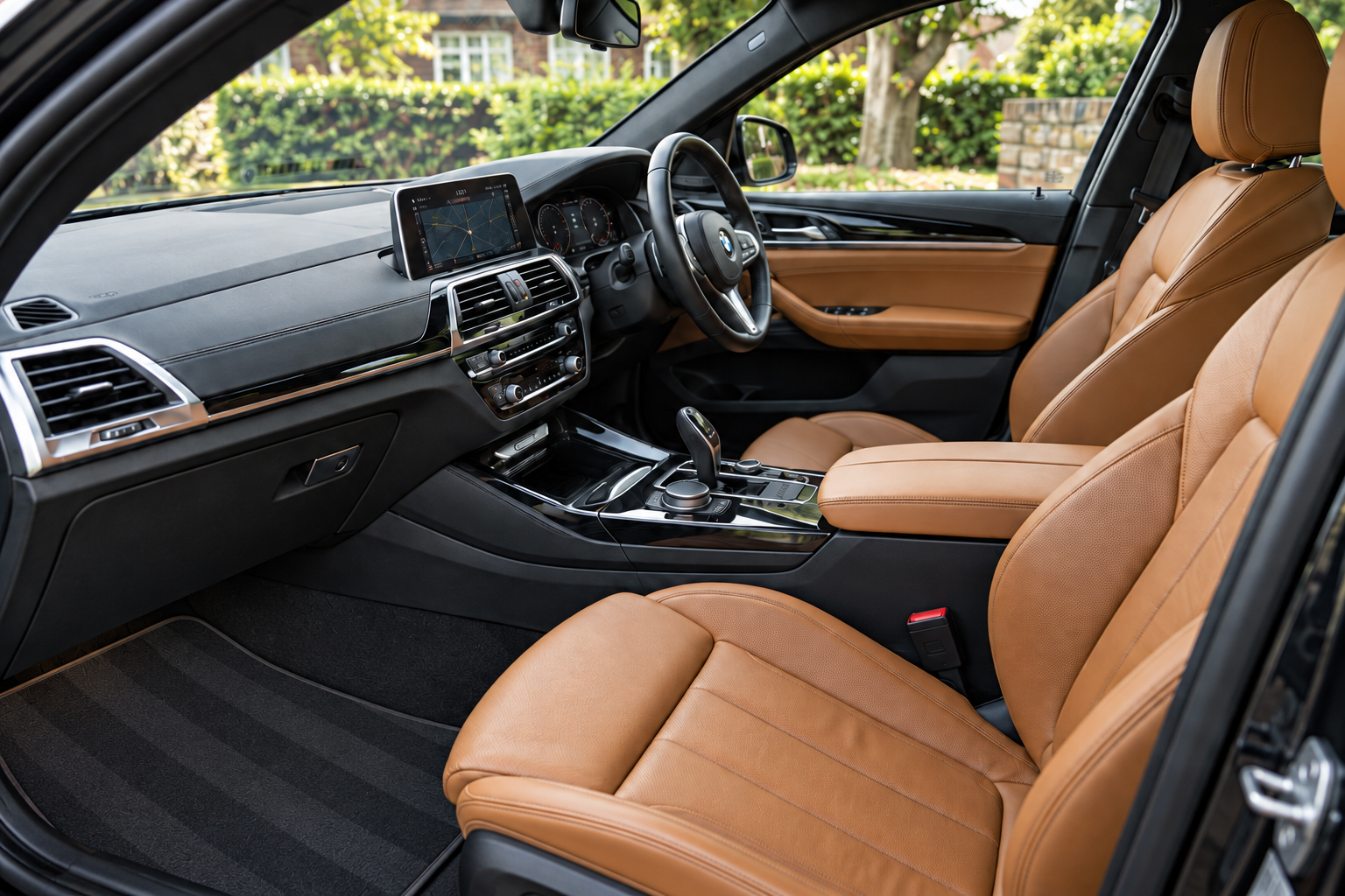 Tan leather car interior with vacuum lines on the floor mat